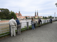 People take pictures of the high water level in the Oder River in Wroclaw, Poland, on September 19, 2024. (