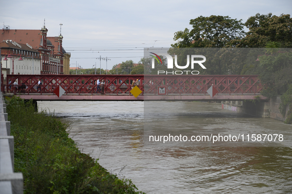 People walk on a bridge during a high water level in the Oder River in Wroclaw, Poland, on September 19, 2024. 