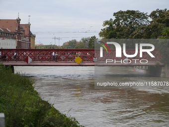 People walk on a bridge during a high water level in the Oder River in Wroclaw, Poland, on September 19, 2024. (