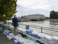 A man takes pictures as he stands on sandbags placed against the Oder river banks during high water in Wroclaw, Poland, on September 19, 202...