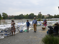 People walk next to sandbags during high waters in the Oder River in Wroclaw, Poland, on September 19, 2024. (