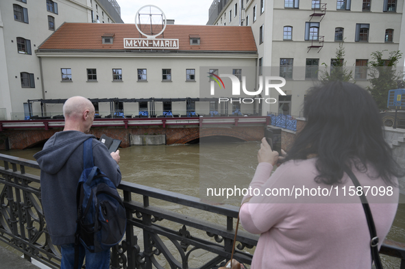 People take pictures of the Oder during high waters in the Oder River in Wroclaw, Poland, on September 19, 2024. 