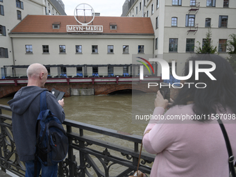 People take pictures of the Oder during high waters in the Oder River in Wroclaw, Poland, on September 19, 2024. (