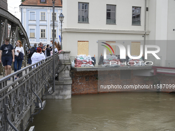 People take pictures from a bridge during high waters in the Oder River in Wroclaw, Poland, on September 19, 2024. (