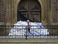 A woman walks past sandbags amassed against a church's door during high waters in the Oder River in Wroclaw, Poland, on September 19, 2024....