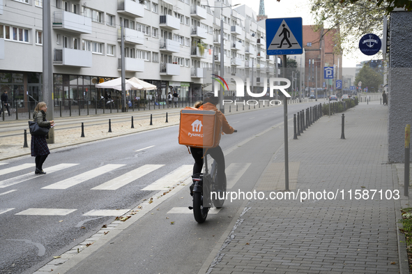 A food delivery courier rides his bike in Wroclaw, Poland, on September 19, 2024. 