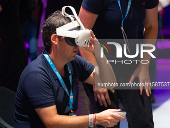 People try on VR sets on the second day of Deutsche Telekom's Digital X event at Media Park in Cologne, Germany, on September 18, 2024. (