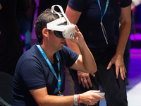 People try on VR sets on the second day of Deutsche Telekom's Digital X event at Media Park in Cologne, Germany, on September 18, 2024. (