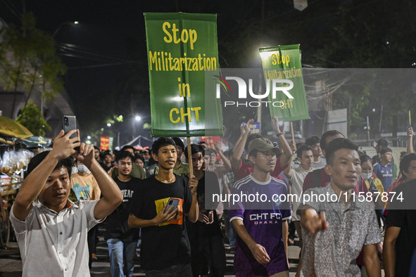 Protesters hold placards during the protest in Dhaka, Bangladesh, on September 19, 2024, against Bengali settler attacks on the Indigenous c...