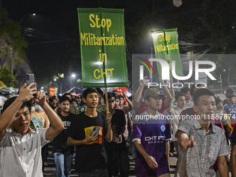 Protesters hold placards during the protest in Dhaka, Bangladesh, on September 19, 2024, against Bengali settler attacks on the Indigenous c...