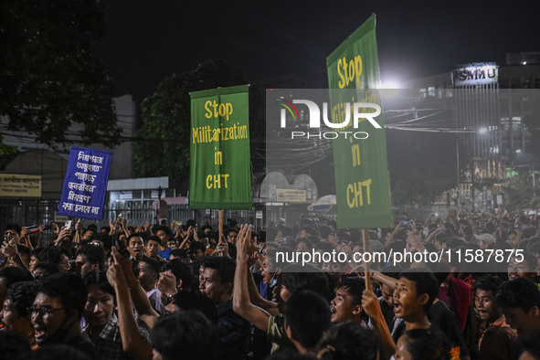 Protesters hold placards during the protest in Dhaka, Bangladesh, on September 19, 2024, against Bengali settler attacks on the Indigenous c...