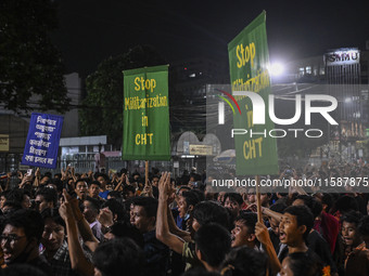 Protesters hold placards during the protest in Dhaka, Bangladesh, on September 19, 2024, against Bengali settler attacks on the Indigenous c...