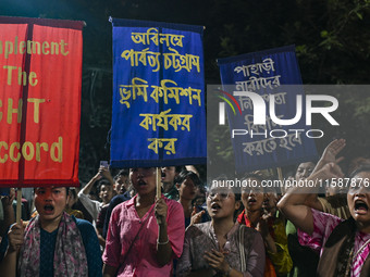 Protesters hold placards during the protest in Dhaka, Bangladesh, on September 19, 2024, against Bengali settler attacks on the Indigenous c...