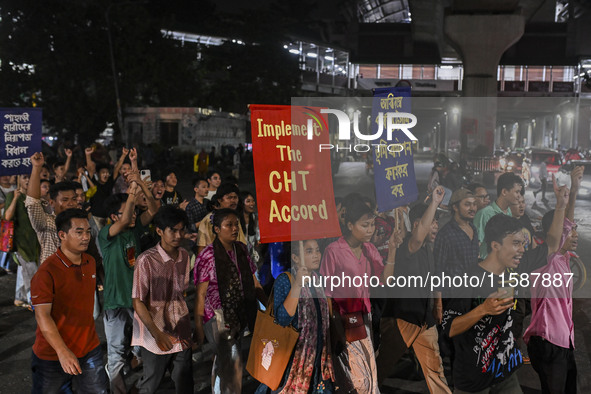 Protesters hold placards during the protest in Dhaka, Bangladesh, on September 19, 2024, against Bengali settler attacks on the Indigenous c...