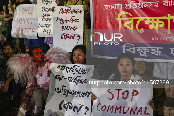 Protesters hold placards during the protest in Dhaka, Bangladesh, on September 19, 2024, against Bengali settler attacks on the Indigenous c...