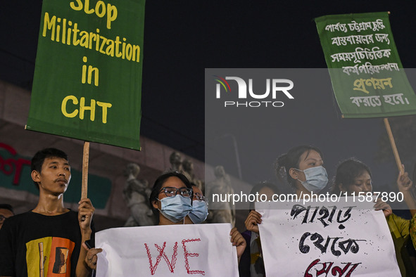 Protesters hold placards during the protest in Dhaka, Bangladesh, on September 19, 2024, against Bengali settler attacks on the Indigenous c...