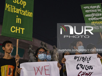 Protesters hold placards during the protest in Dhaka, Bangladesh, on September 19, 2024, against Bengali settler attacks on the Indigenous c...