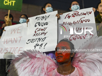 Protesters hold placards during the protest in Dhaka, Bangladesh, on September 19, 2024, against Bengali settler attacks on the Indigenous c...