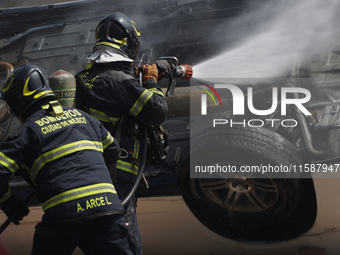 Members of the Heroic Fire Brigade put out fires in a car during the National Fire Drill 2024 in the Zocalo of Mexico City, Mexico, on Septe...