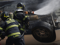 Members of the Heroic Fire Brigade put out fires in a car during the National Fire Drill 2024 in the Zocalo of Mexico City, Mexico, on Septe...