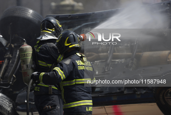 Members of the Heroic Fire Brigade put out fires in a car during the National Fire Drill 2024 in the Zocalo of Mexico City, Mexico, on Septe...