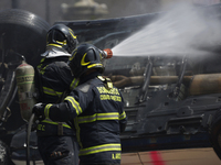 Members of the Heroic Fire Brigade put out fires in a car during the National Fire Drill 2024 in the Zocalo of Mexico City, Mexico, on Septe...