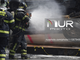 Members of the Heroic Fire Brigade put out fires in a car during the National Fire Drill 2024 in the Zocalo of Mexico City, Mexico, on Septe...