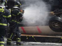 Members of the Heroic Fire Brigade put out fires in a car during the National Fire Drill 2024 in the Zocalo of Mexico City, Mexico, on Septe...