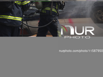 Members of the Heroic Fire Brigade put out fires in a car during the National Fire Drill 2024 in the Zocalo of Mexico City, Mexico, on Septe...