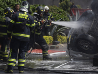 Members of the Heroic Fire Brigade put out fires in a car during the National Fire Drill 2024 in the Zocalo of Mexico City, Mexico, on Septe...