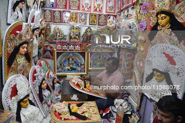 An artisan paints a decoration of the Hindu goddess Durga inside a shop ahead of the Durga Puja festival in Kolkata, India, on September 20,...