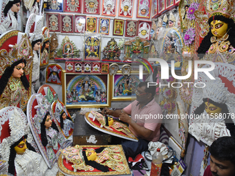 An artisan paints a decoration of the Hindu goddess Durga inside a shop ahead of the Durga Puja festival in Kolkata, India, on September 20,...