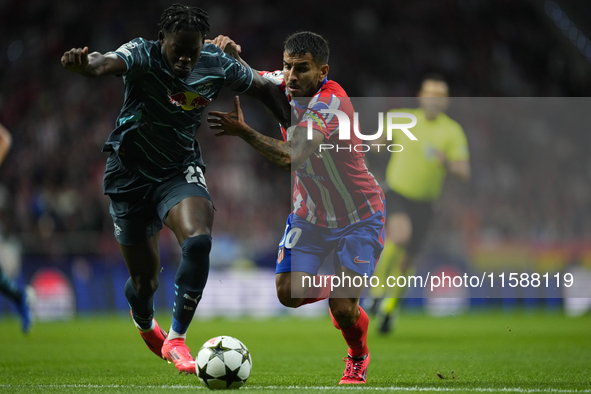 Angel Correa right winger of Atletico de Madrid and Argentina  and Castello Lukeba centre-back of RB Leipzig and France compete for the ball...