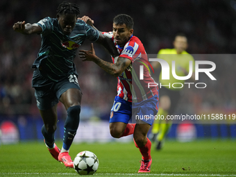 Angel Correa right winger of Atletico de Madrid and Argentina  and Castello Lukeba centre-back of RB Leipzig and France compete for the ball...