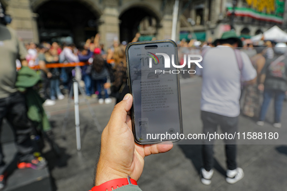 A person shows the cell phone earthquake alert during the national earthquake drill with a magnitude of 7.5 on the Richter scale with an epi...