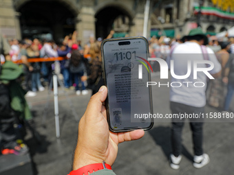 A person shows the cell phone earthquake alert during the national earthquake drill with a magnitude of 7.5 on the Richter scale with an epi...