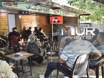 People watch Hezbollah leader Hassan Nasrallah on a television screen as he addresses the nation via video link at a cafe in the Shiyah neig...