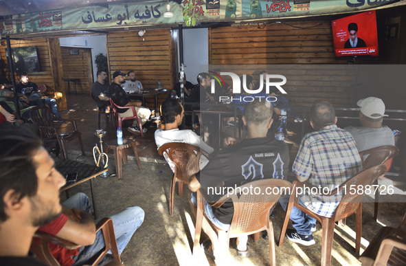 People watch Hezbollah leader Hassan Nasrallah on a television screen as he addresses the nation via video link at a cafe in the Shiyah neig...