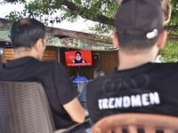 People watch Hezbollah leader Hassan Nasrallah on a television screen as he addresses the nation via video link at a cafe in the Shiyah neig...