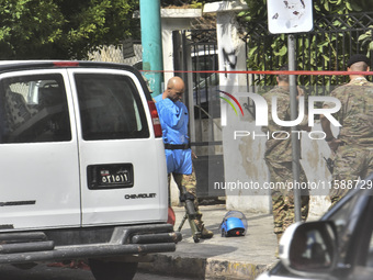 An explosives expert from the Lebanese army prepares to remove a bomb thrown in a small garden next to a public road in Beirut, Lebanon, on...