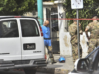 An explosives expert from the Lebanese army prepares to remove a bomb thrown in a small garden next to a public road in Beirut, Lebanon, on...