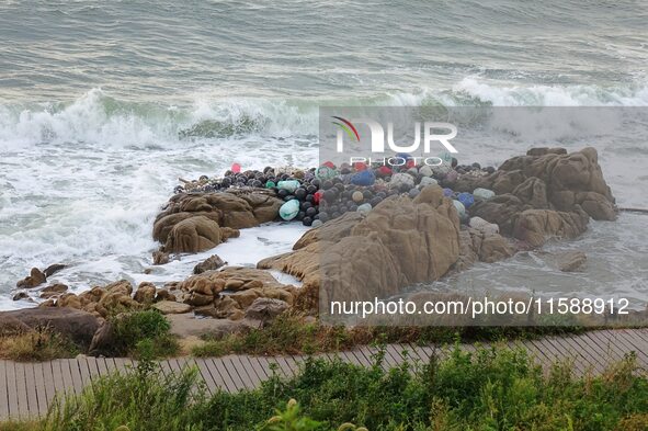 Floating balls for offshore farming come ashore with waves affected by Typhoon Pulasan in Qingdao, China, on September 20, 2024. 