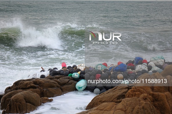 Floating balls for offshore farming come ashore with waves affected by Typhoon Pulasan in Qingdao, China, on September 20, 2024. 