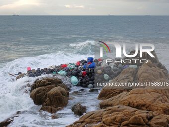 Floating balls for offshore farming come ashore with waves affected by Typhoon Pulasan in Qingdao, China, on September 20, 2024. (