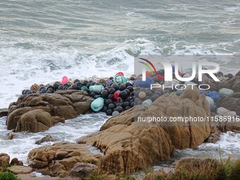 Floating balls for offshore farming come ashore with waves affected by Typhoon Pulasan in Qingdao, China, on September 20, 2024. (