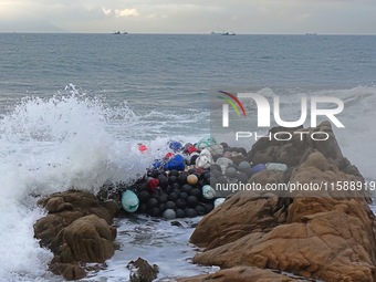 Floating balls for offshore farming come ashore with waves affected by Typhoon Pulasan in Qingdao, China, on September 20, 2024. (