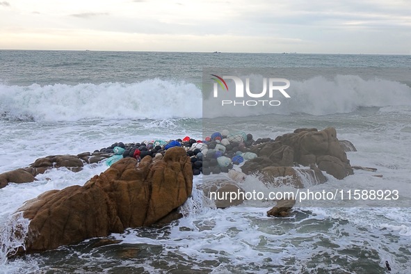 Floating balls for offshore farming come ashore with waves affected by Typhoon Pulasan in Qingdao, China, on September 20, 2024. 