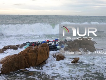 Floating balls for offshore farming come ashore with waves affected by Typhoon Pulasan in Qingdao, China, on September 20, 2024. (