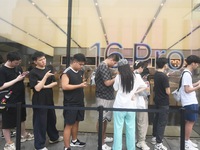 Customers line up outside the Apple flagship store as they wait to enter the store to buy the iPhone 16 in Hangzhou, China, on September 20,...