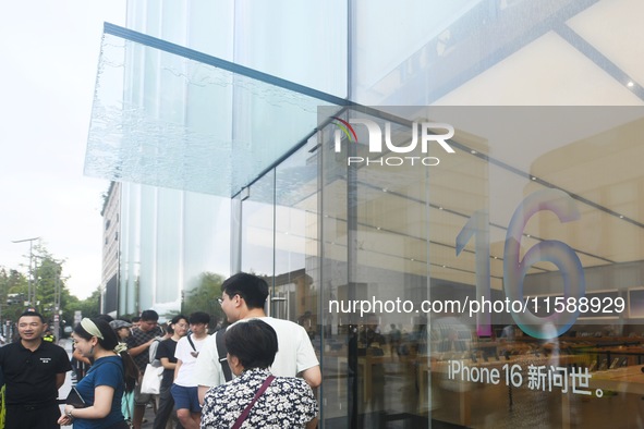 Customers line up outside the Apple flagship store as they wait to enter the store to buy the iPhone 16 in Hangzhou, China, on September 20,...